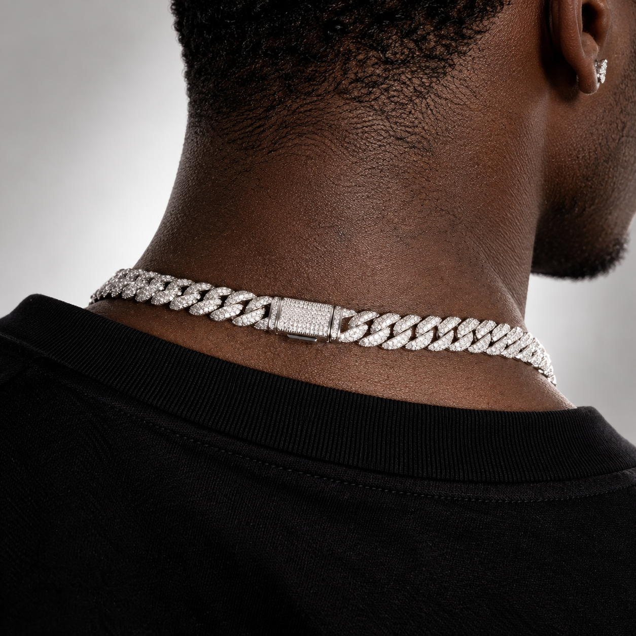 Silver-tone iced Miami Cuban chain seen from behind, pave box clasp at the nape